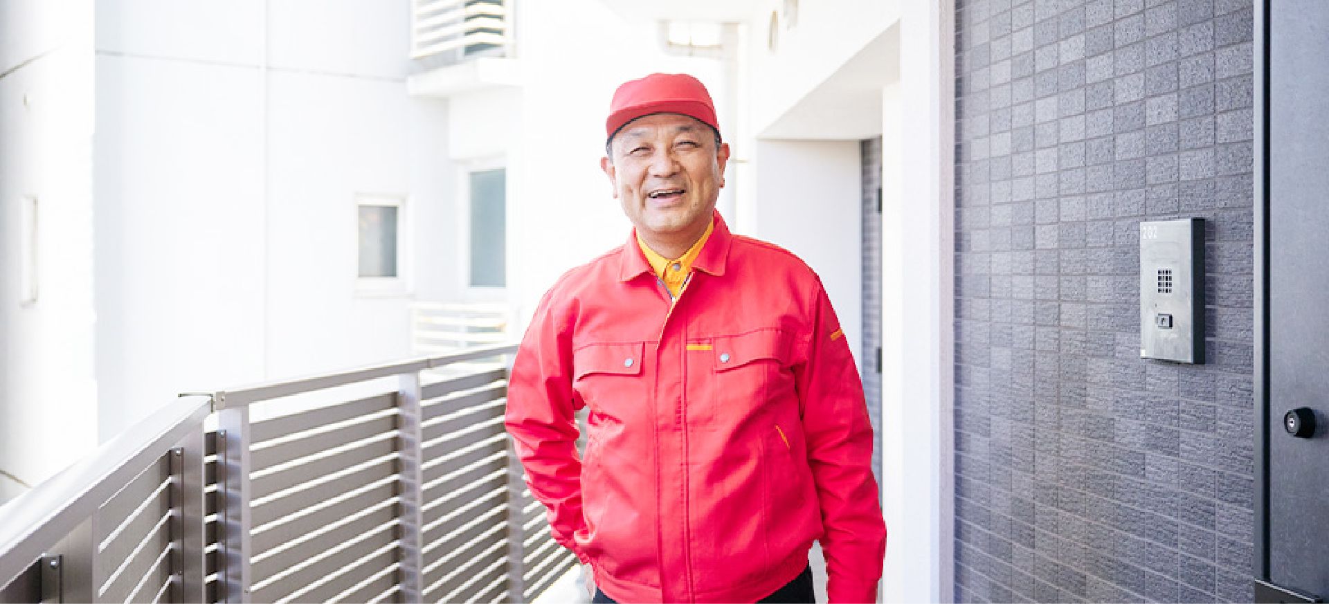 マンション内で笑顔で立っているK.K.さん